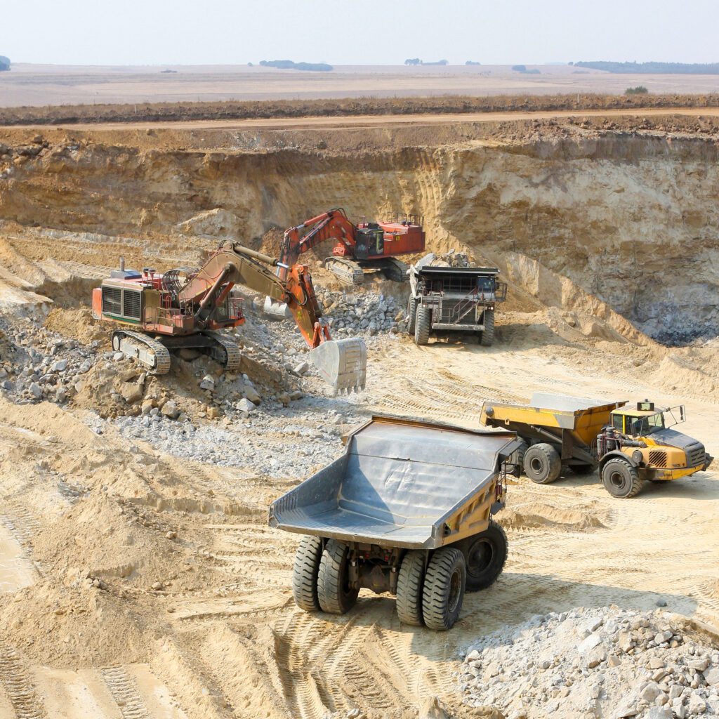 Open pit mining operation with excavators and haul trucks, representing mining and resources workforce projects across Western Australia and Queensland.